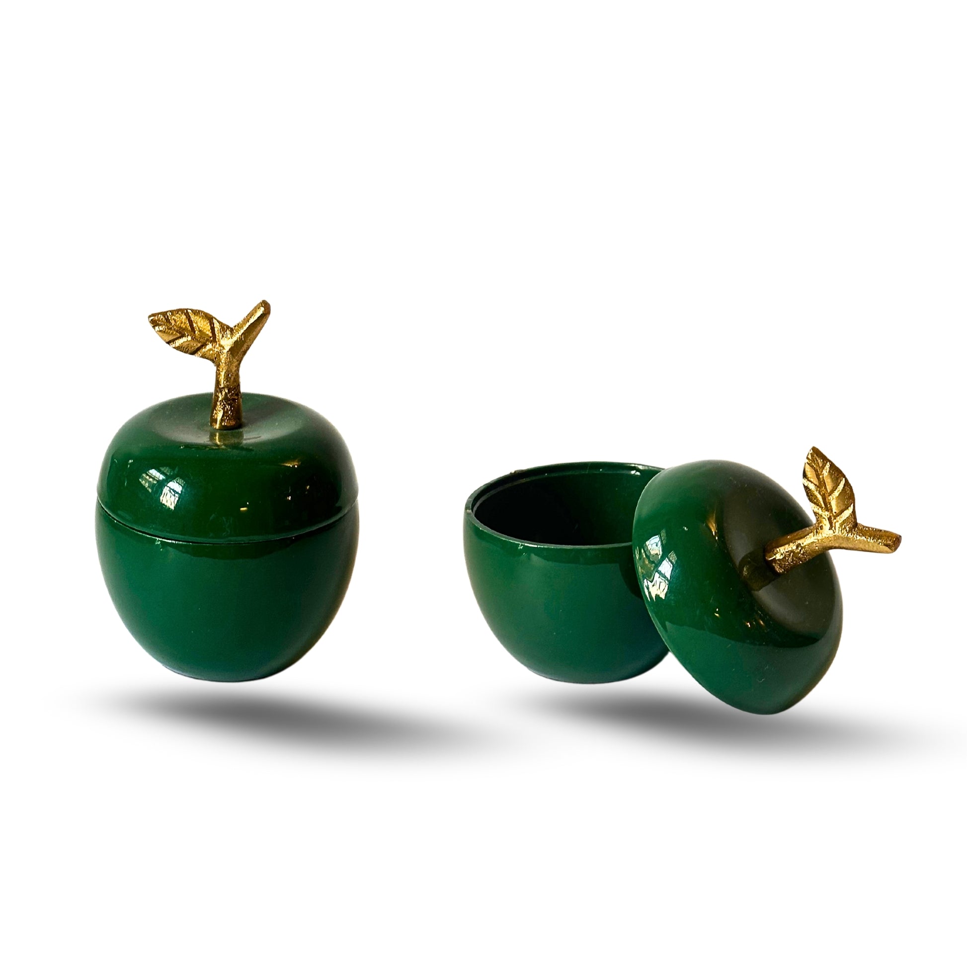 Green apple-shaped metal jars with golden stem for décor and dry storage.